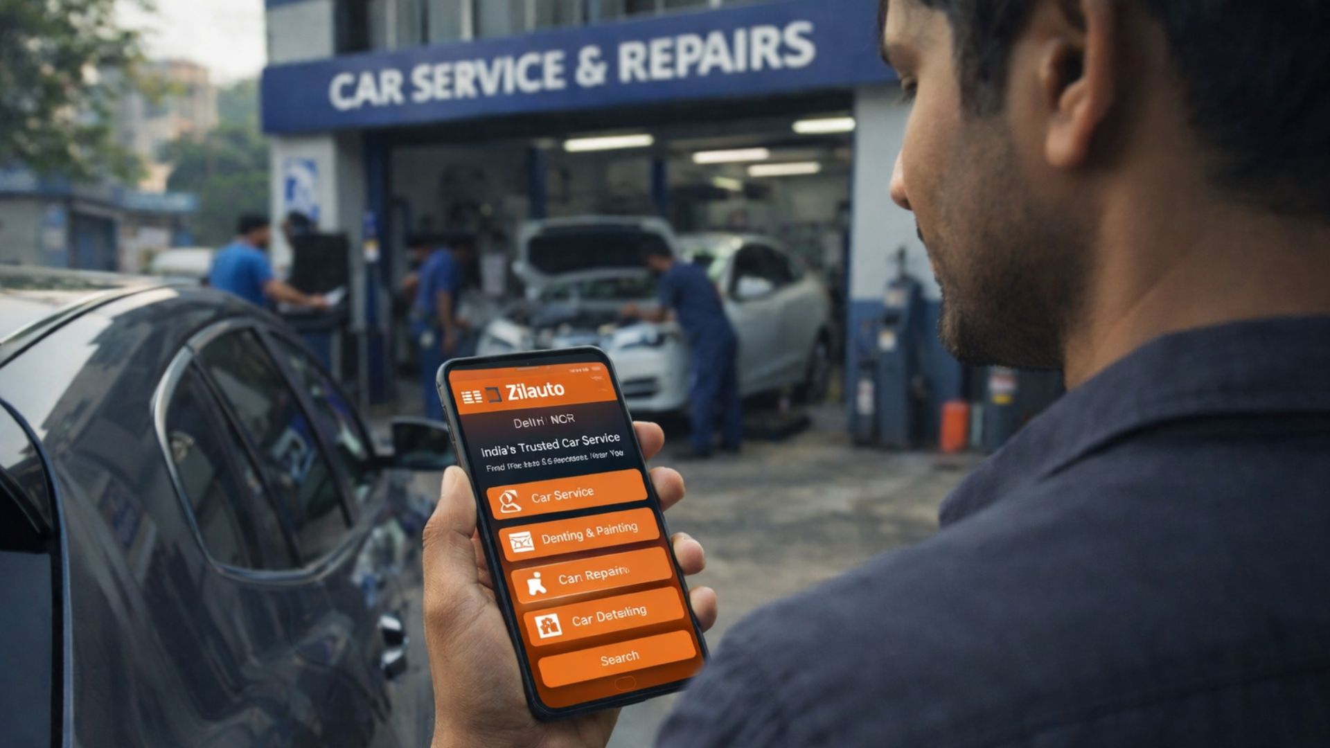 Car owner booking a car service from Zilauto on smartphone outside a car workshop